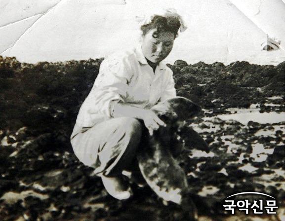1950년대 말 독도에서 제주시 한림읍 협재리 출신 김공자 해녀가 강치를 안고 있는 모습 (사진 = 경상북도).jpg